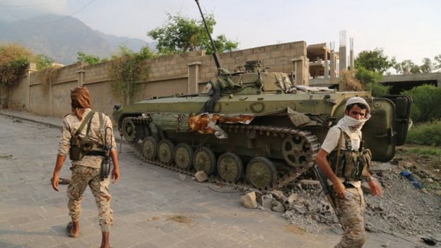 Pro-government fighter army troops walk in a position they retook from Houthi fighters near the Republican Palace in the northwestern city of Taiz