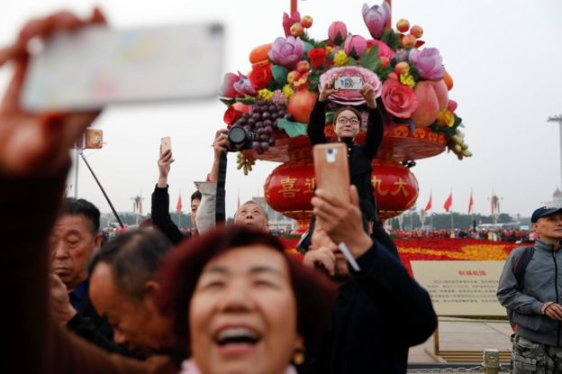 People take pictures as they attend a flag-raising ceremony at Tiananmen Square ahead of the 19th National Congress of the Communist Party of China in Beijing, China, 17 October 2017.