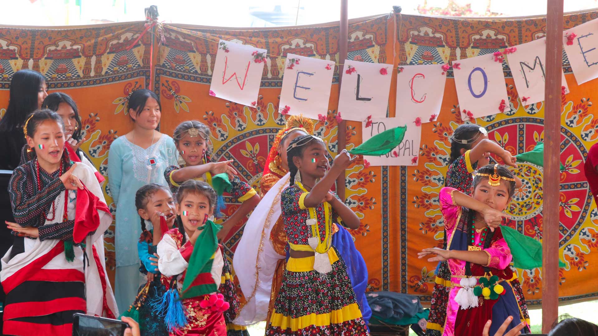 Ragazze nepalesi con il costume tradizionale danzano e danno il benvenuto ai visitatori