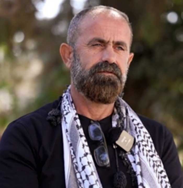 Primo piano di Mahmoud con sguardo triste e assorto.