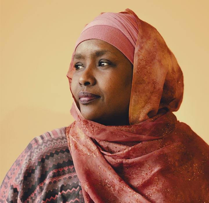 Il viso di Edna in primo piano che guarda verso destra con un sorriso sulle labbra.