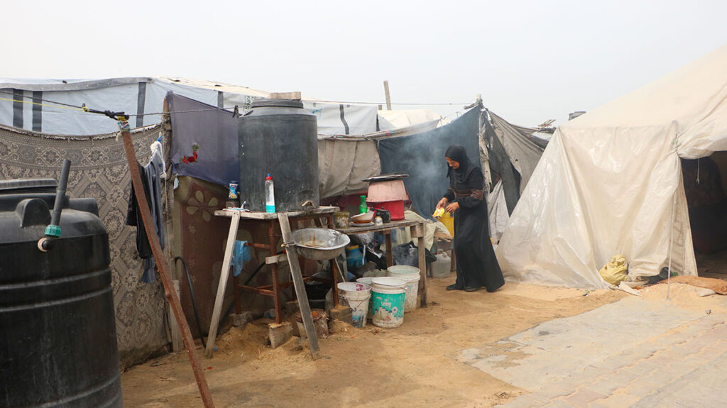 Taghreed una signora palestinese sta preparando da mangiare in un campo di tende e cartoni