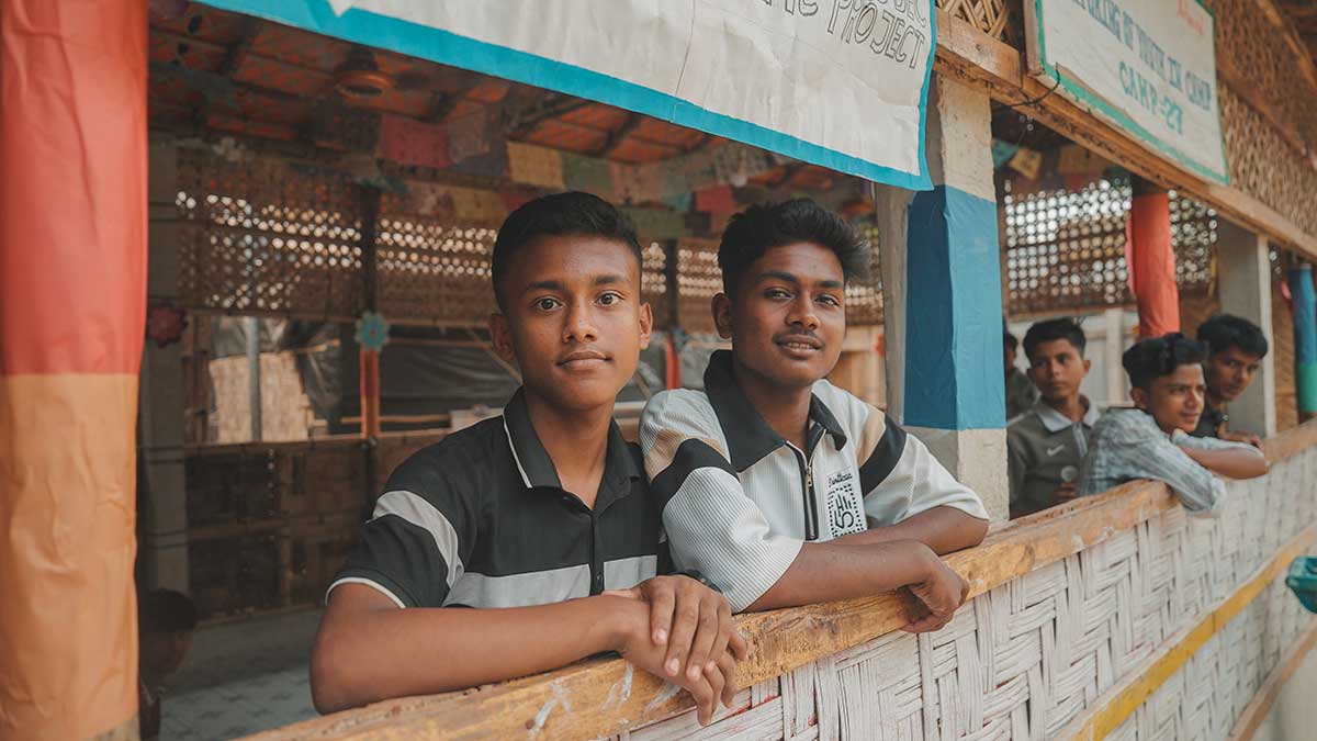 Cox's Bazar. Bambini affacciati a un balconcino guardano sorridenti verso l'obiettivo