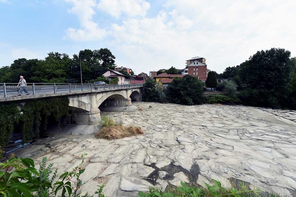 Torino. Vista di un ponte con sotto terreno brullo senza una goccia di acqua.