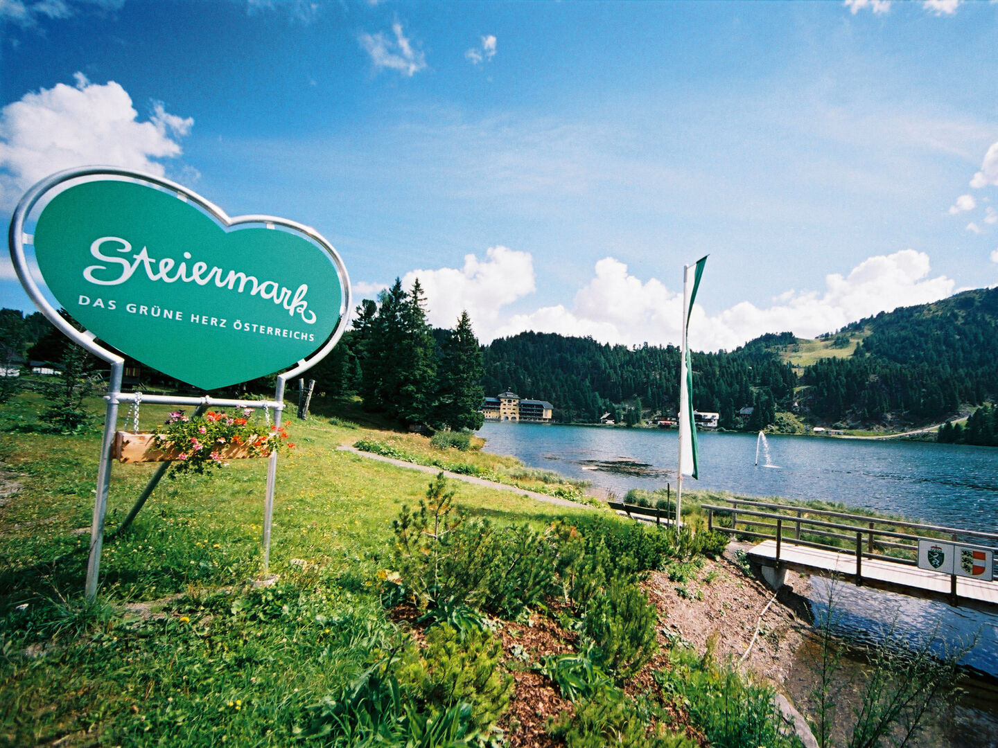 Natur und ein Aufsteller mit dem Grünen Herz der Steiermark