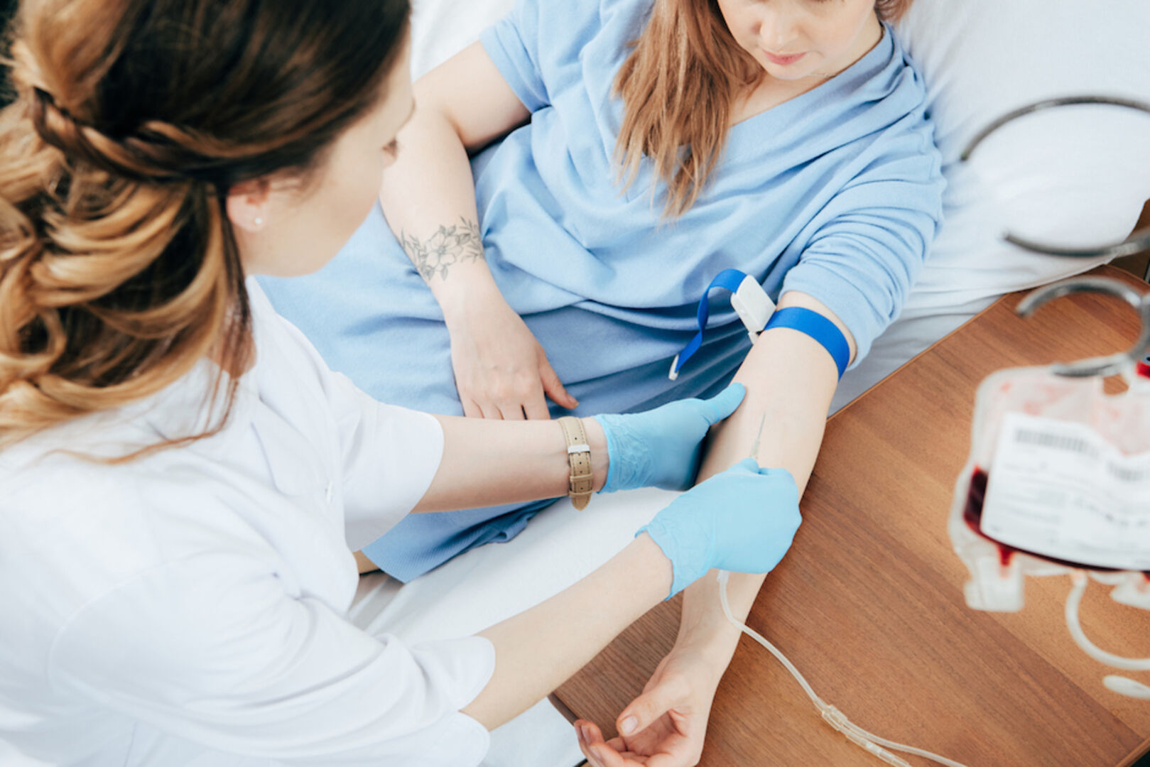 Eine Ärztin nimmt einer jungen Frau Blut ab