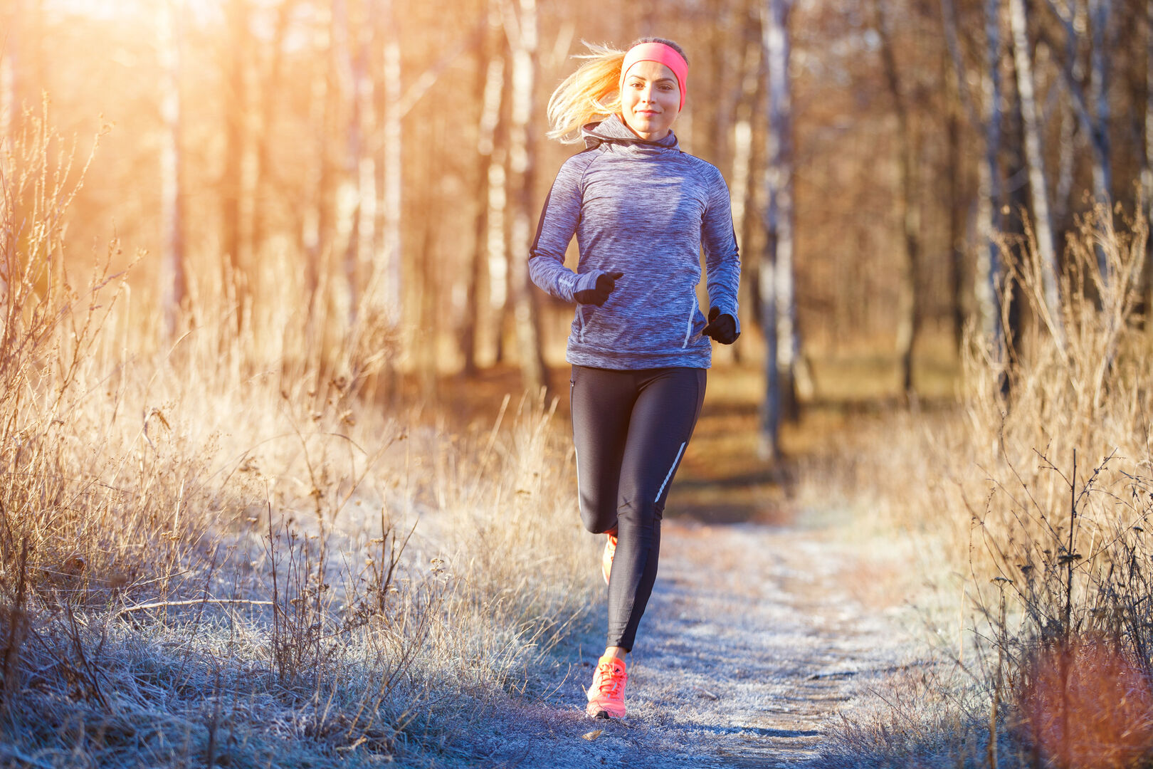 Gesund durch den Herbst: Joggerin läuft durch Herbstlandschaft