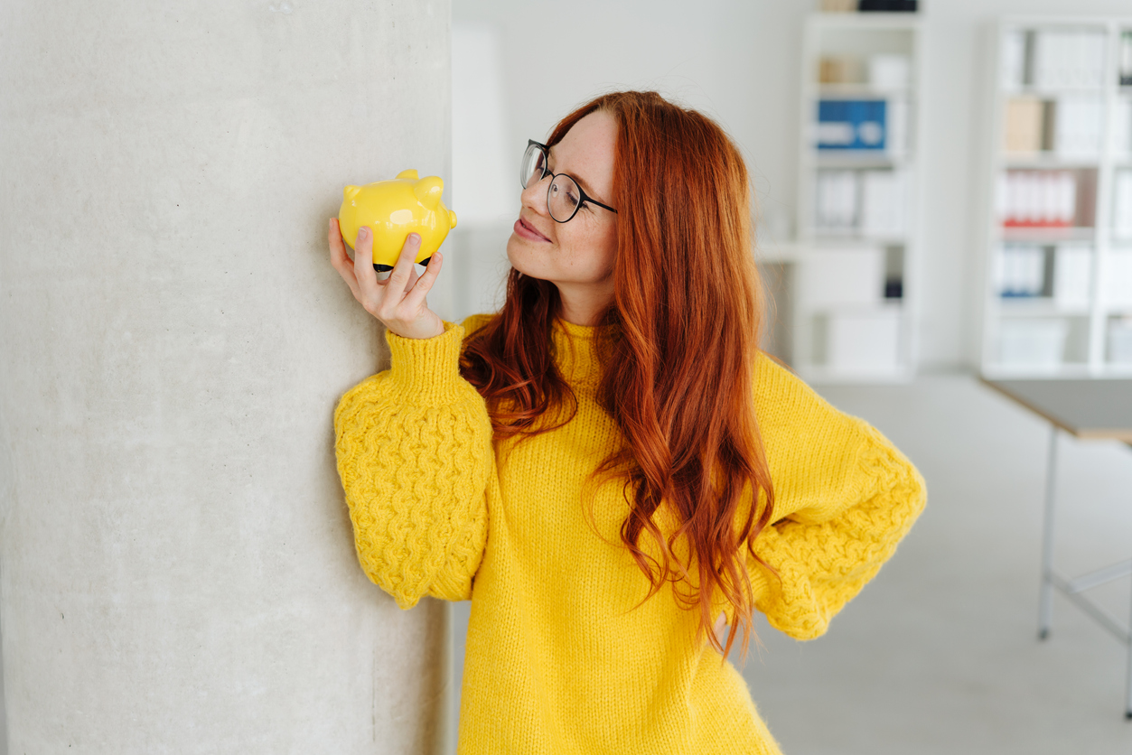 Junge Frau mit Sparschwein | Credit: iStock.com/stockfour