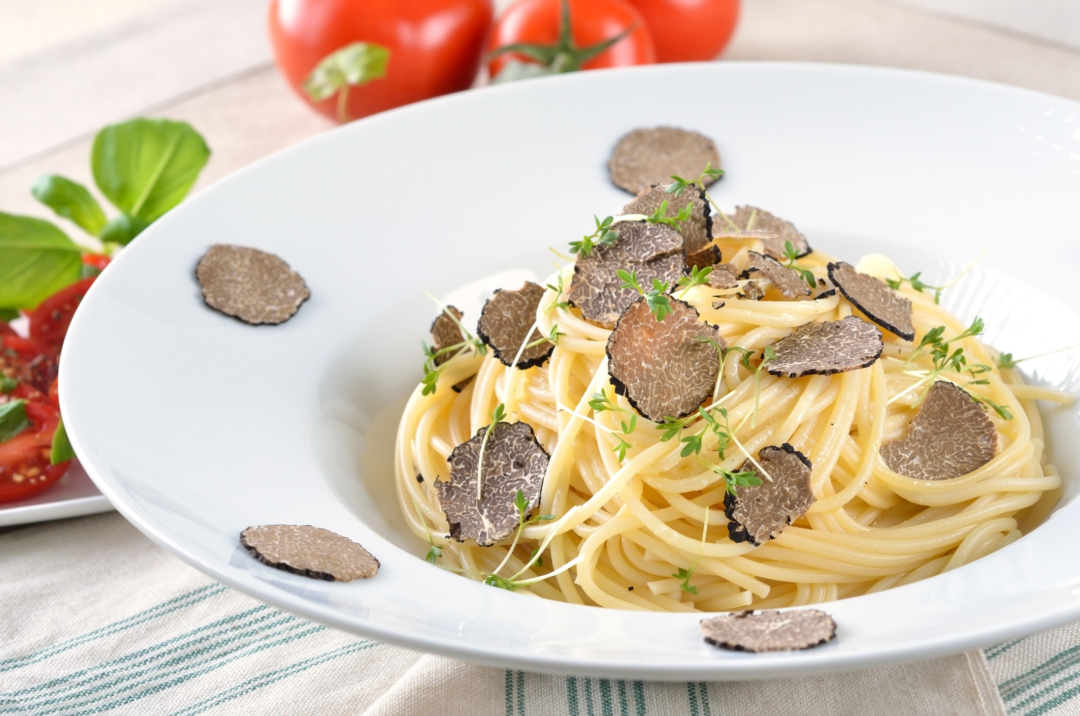 Ein Teller mit Trüffelspaghetti auf einem weiß gedeckten Tisch