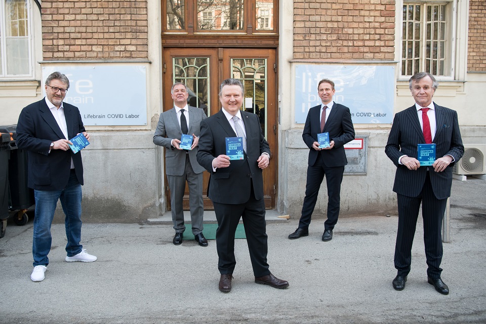 Fünf Männer im Anzug halten eine Broschüre