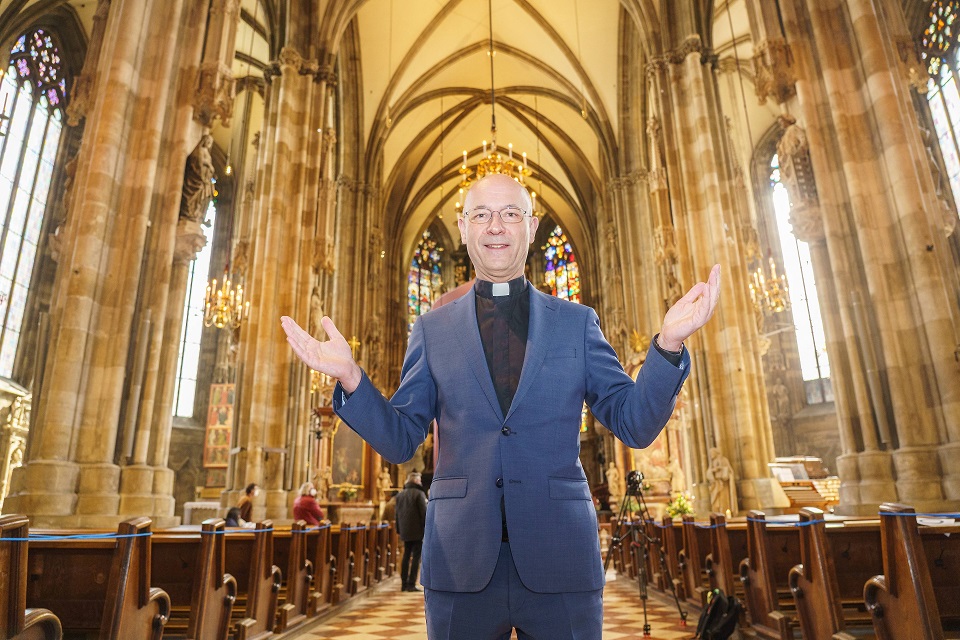 Dompfarrer Toni Faber steht mit halb offenen Armen im Stephansdom.