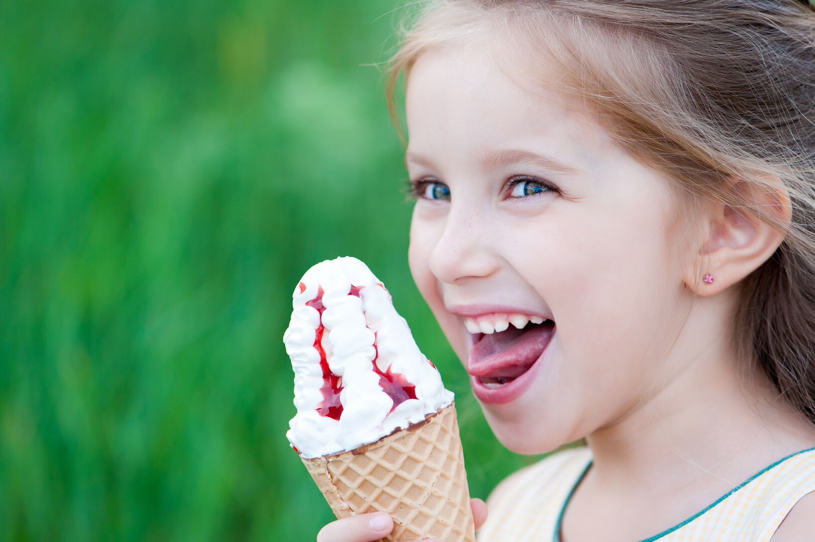 Kleines Mädchen isst ein großes Eis