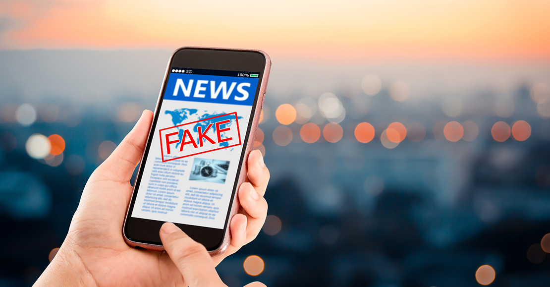 Smartphone mit einer als Fake gekennzeichneten Nachrichtenseite