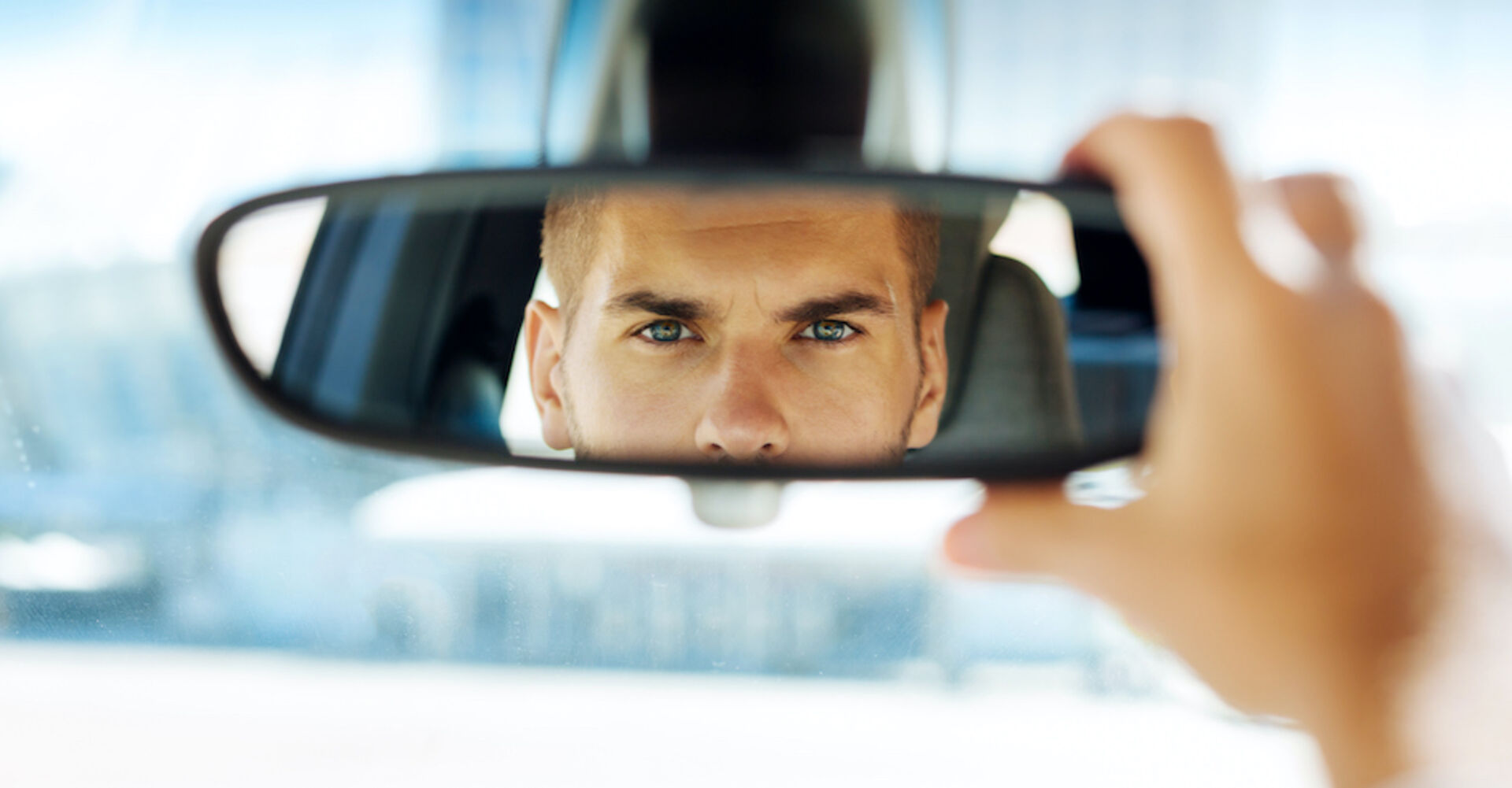 Taxifahrer schaut in den Rückspiegel | Credit: iStock.com/Zinkevych