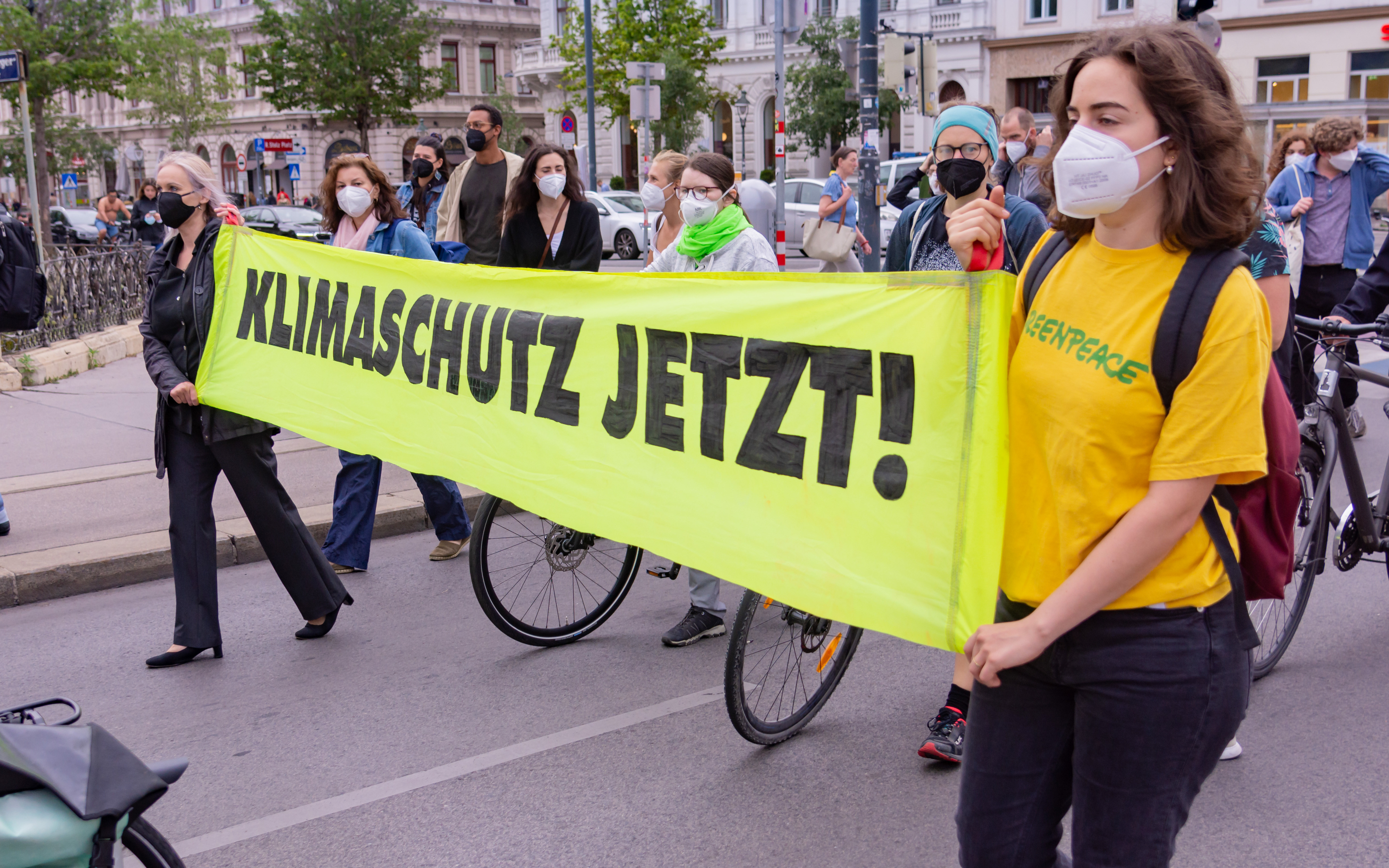 Eine Straßendemo, Teilnehmer halten ein Transparent Klimaschutz jetzt!