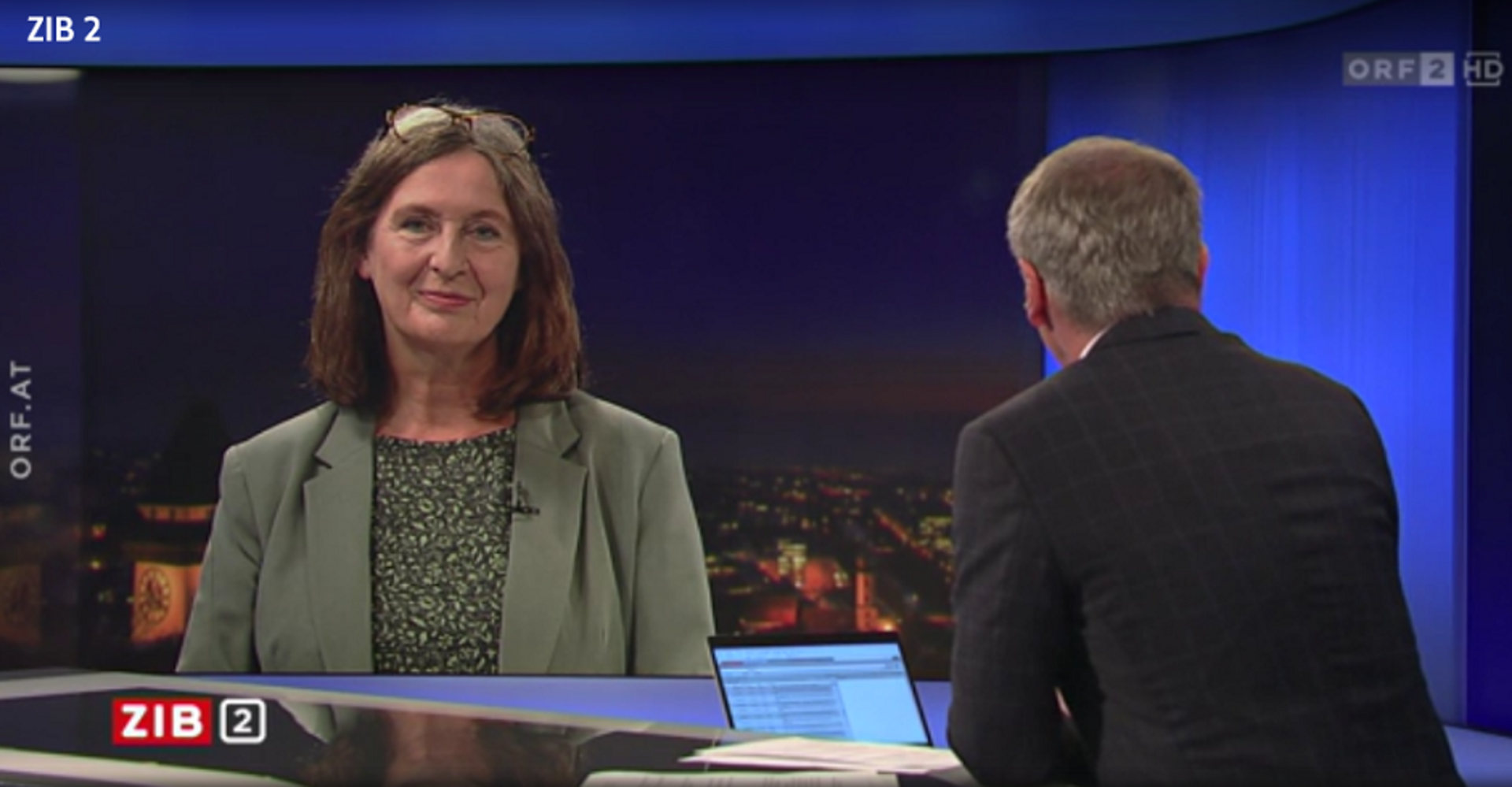 Ein Screenshot der Zeit im Bild: Armin Wolf sitzt mit dem Rücken zur Kamera, Interviewpartnerin Elke Kahr ist am Monitor eingeplendet. Oben rechts das Logo des ORF2, unten links das Logo der Zib 2. An der Seite der Vermerk: "orf.at"