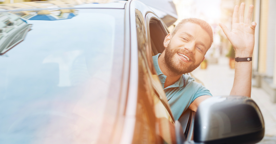 Mann winkt aus dem Auto| Credit: iStock.com/Zinkevych