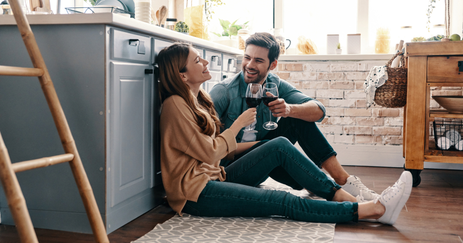 Glückliches Paar beim Anstoßen auf ihr gemeinsames Eigenheim | Credit: iStock.com/g-stockstudio