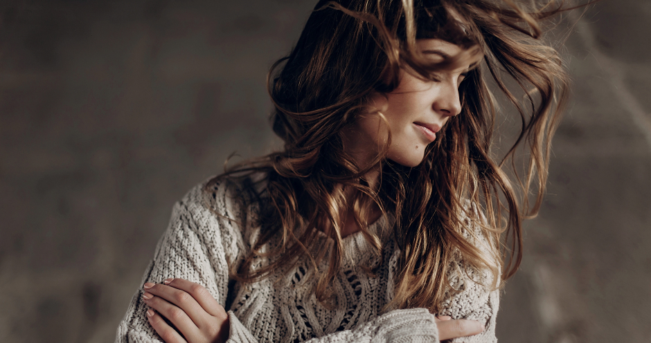 Coole, junge Frau im Wollpullover schüttelt ihr langes Haar | Credit: iStock.com/Bogdan Kurylo