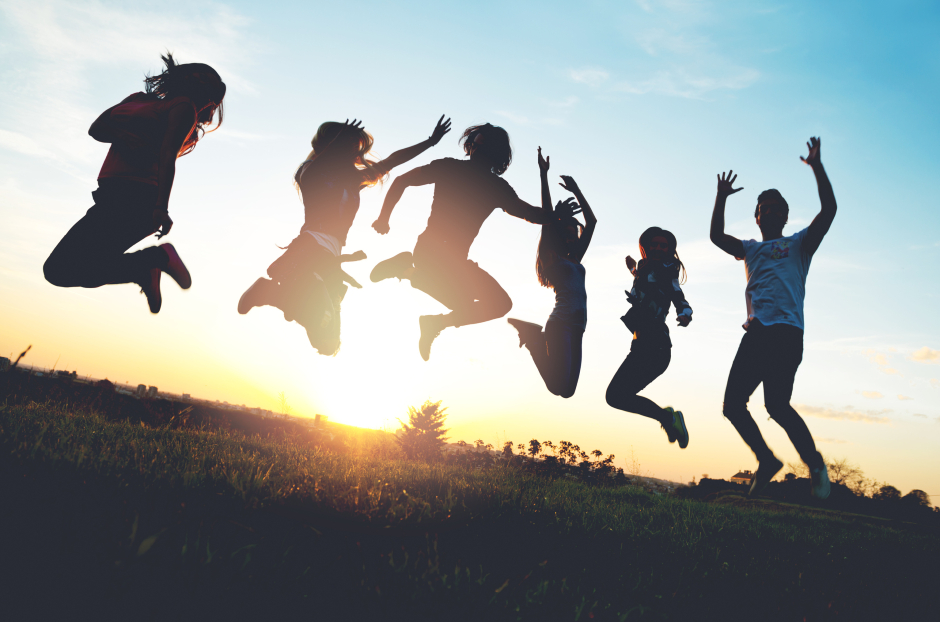 Kinder springen im Sonnenuntergang gemeinsam in die Luft | Credit: iStock.com/Tijana87