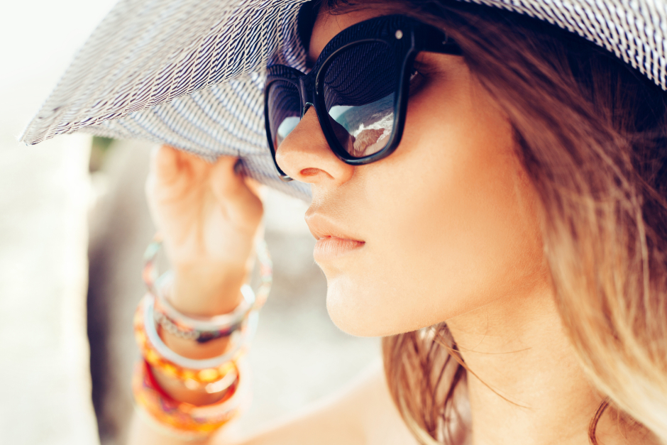 Selbstbewusste junge Frau mit Sonnenbrille und Hut | Credit: iStock.com/JohanJK