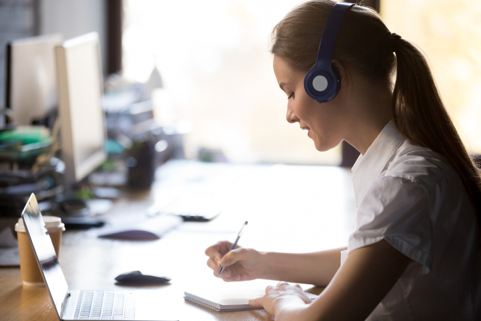 Studentin schreibt während einer Vorlesung via Videokonferenz mit | Credit: iStock.com/fizkes