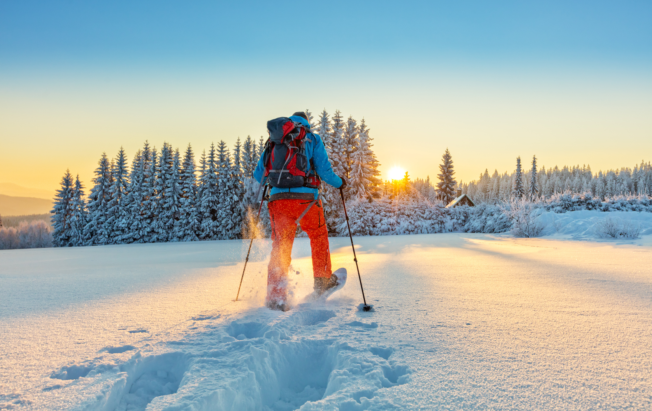 Mann wandert mit Schneeschuhen im Pulverschnee