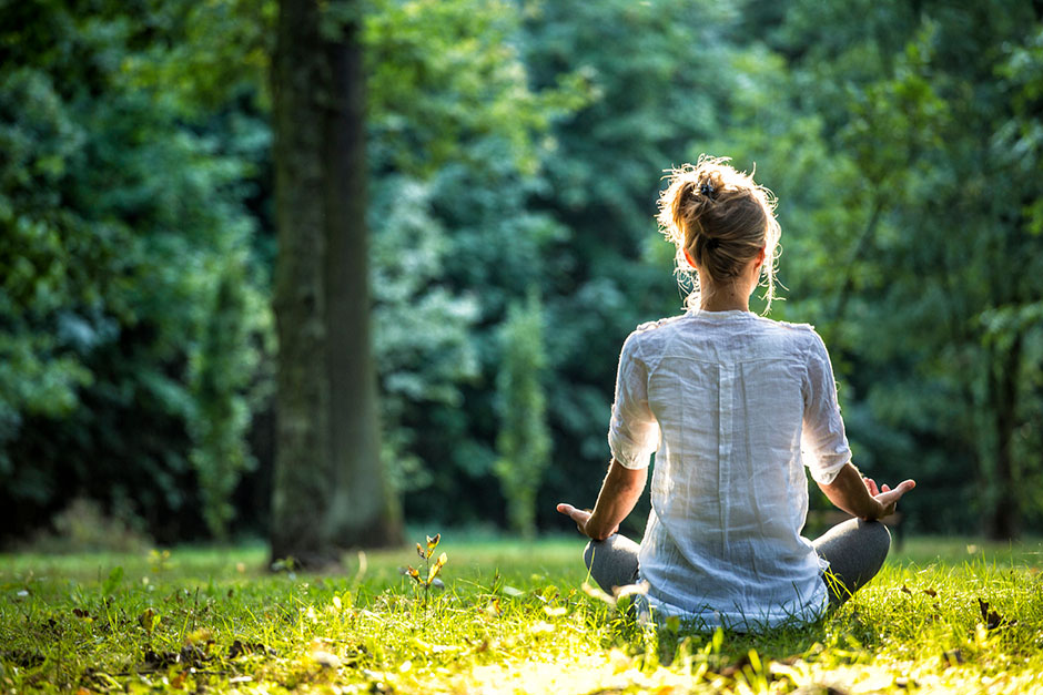 Junge Frau beim Meditieren im Park | Credit: iStock.com/Marcin Wiklik