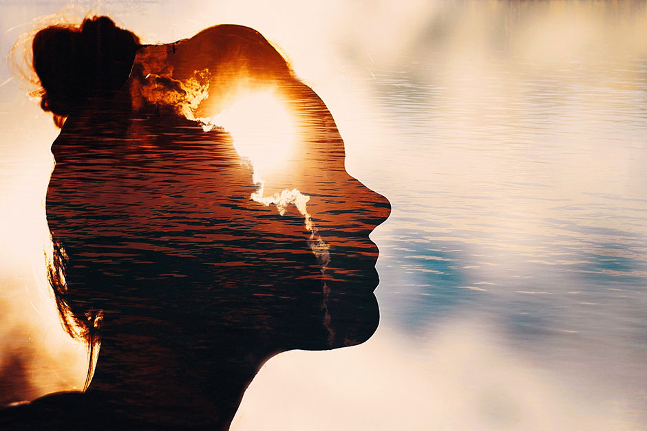 Frau im Sonnenaufgang blickt Richtung Himmel | Credit: iStock.com/primipil