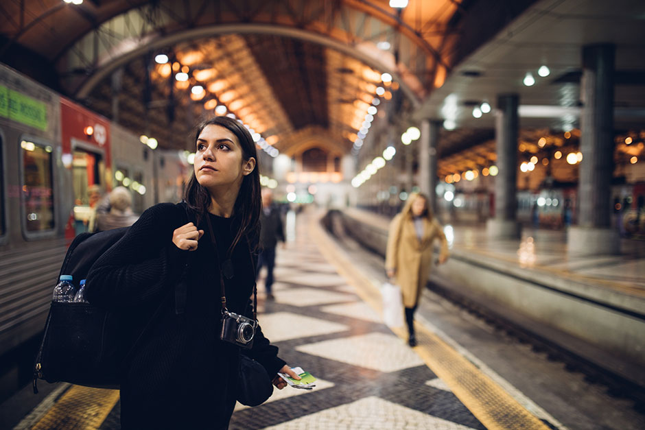 Junge Rucksacktouristin unterwegs am Bahnhof | Credit: iStock.com/eldinhoid
