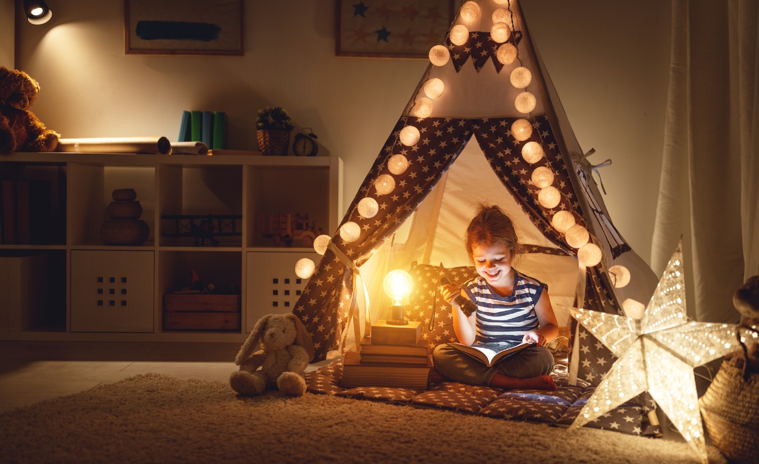 Kind liest im Zelt im Kinderzimmer | Credit: iStock.com/evgenyatamanenko