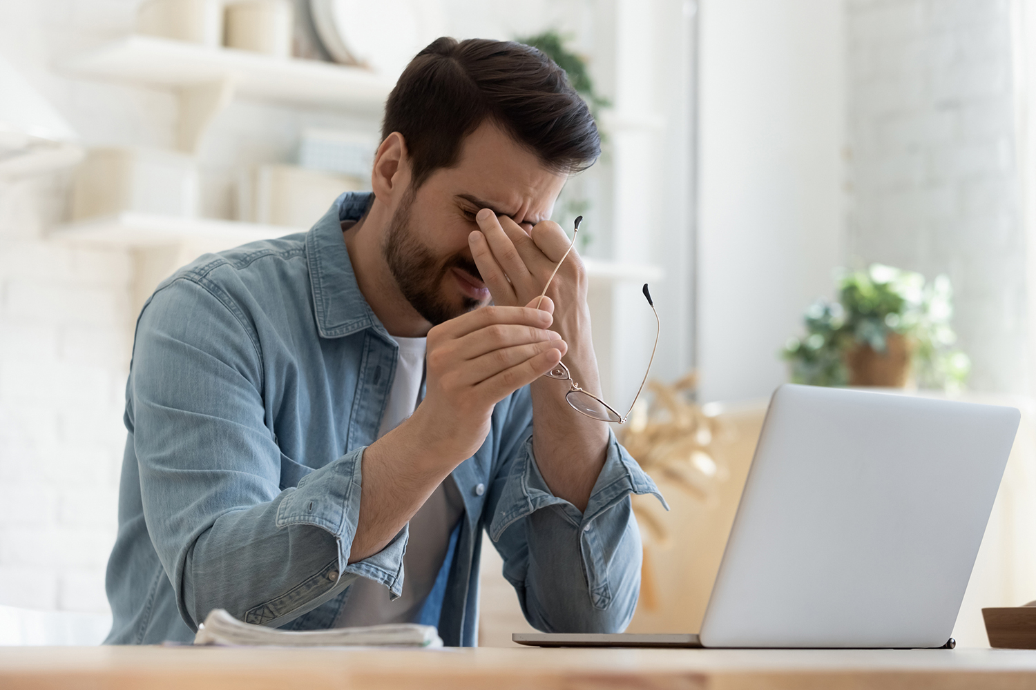 Mann sitzt vor Laptop | Credit: iStock.com/fizkes