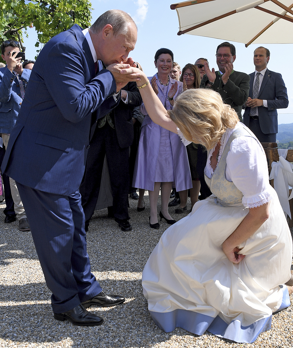 Karin Kneissl knickst im Brautgleid vor Putin, dieser küsst ihr dafür die gereichte Hand.