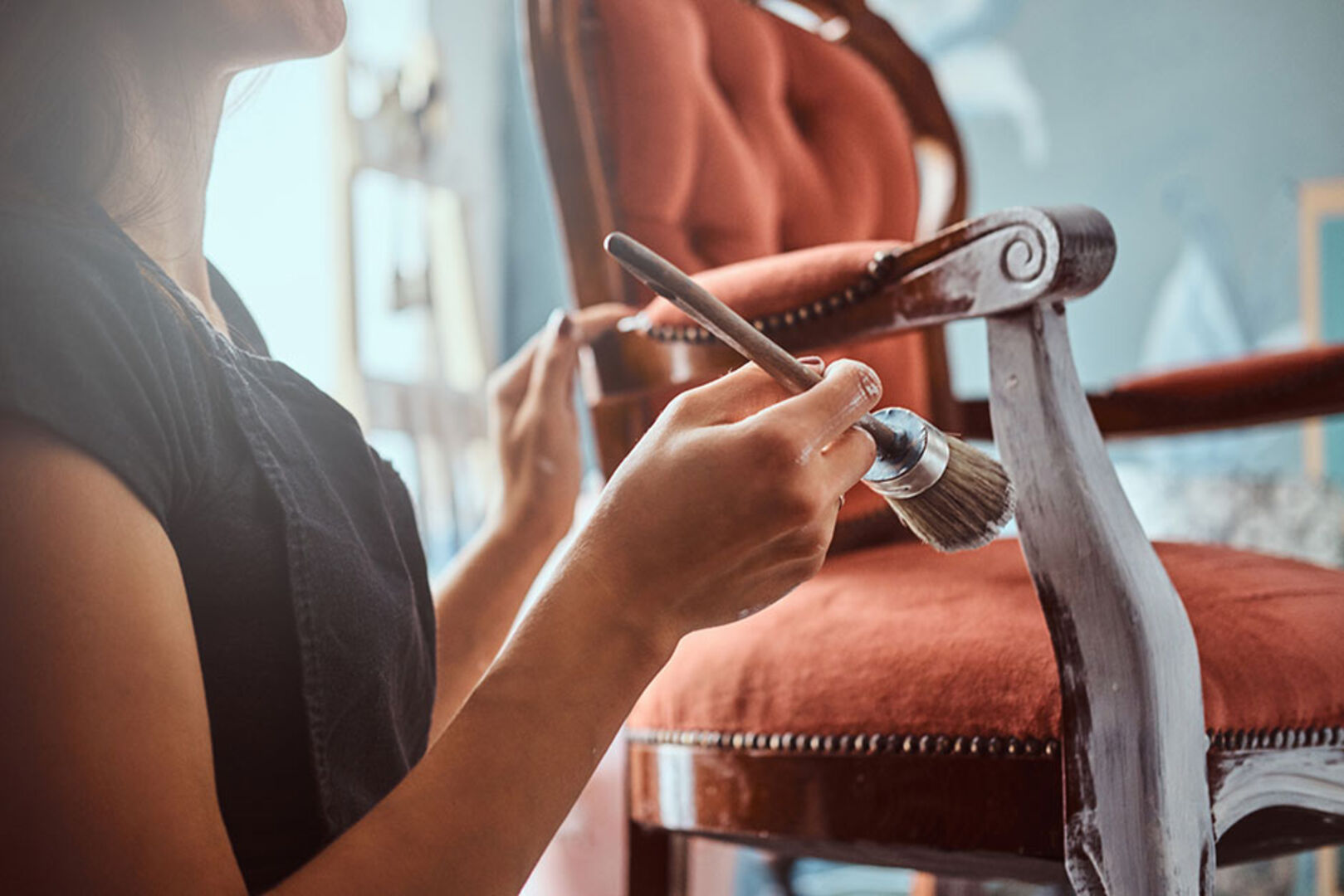 Junge Frau restauriert einen alten Stuhl | Credit: iStock.com/FXQuadro