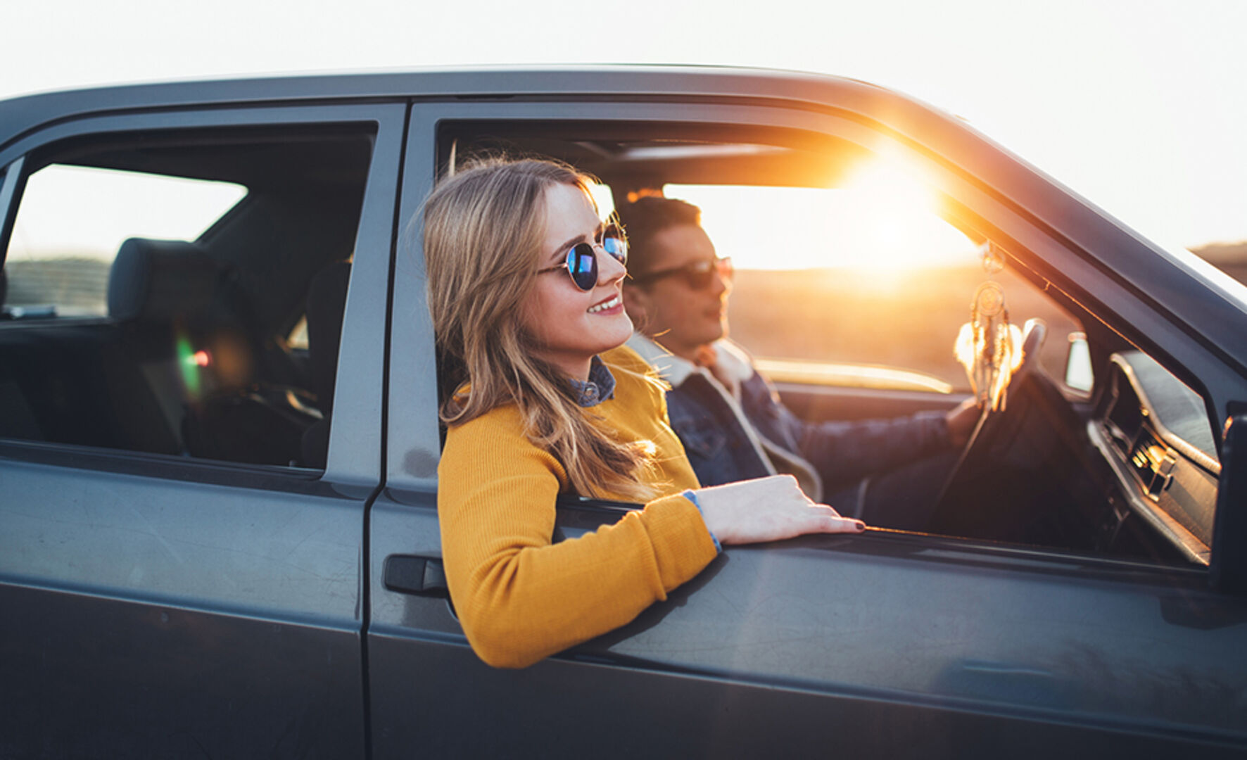 Junger Mann und weibliche Begleitung im Auto unterwegs | Credit: iStock.com/hobo_018