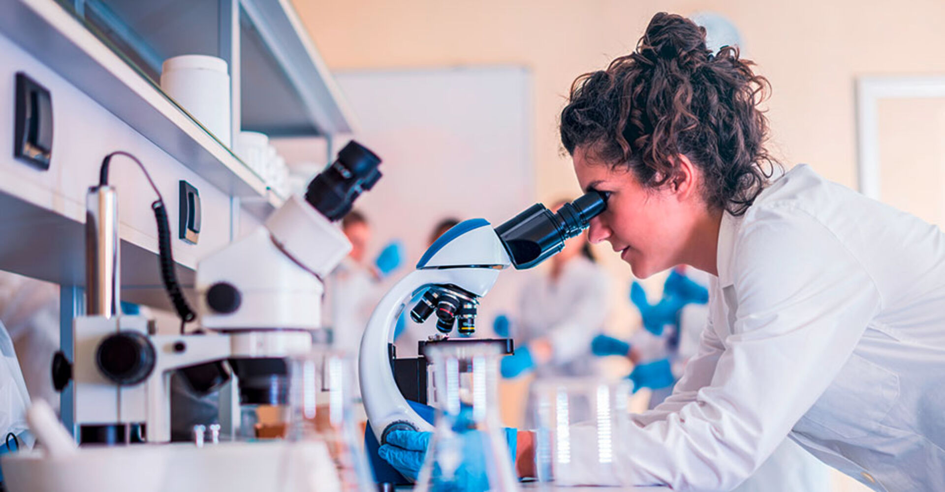 Frau nimmt am Mikroskop im Labor eine Untersuchung vor | Credit: iStock.com/Vladimir Borovic