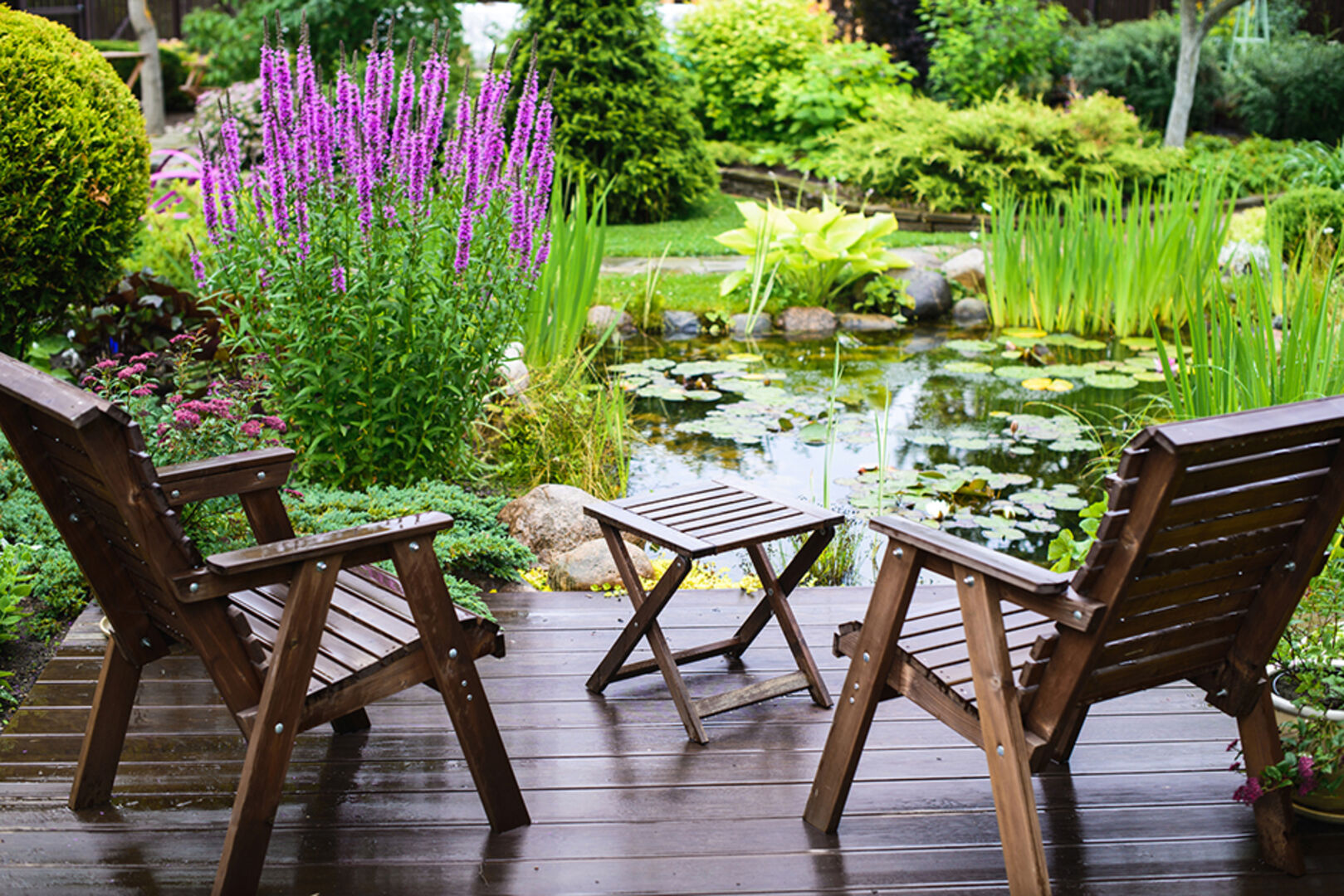 Kleine Holzterrasse mit Blick auf einen Gartenteich | Credit: iStock.com/Nadanka