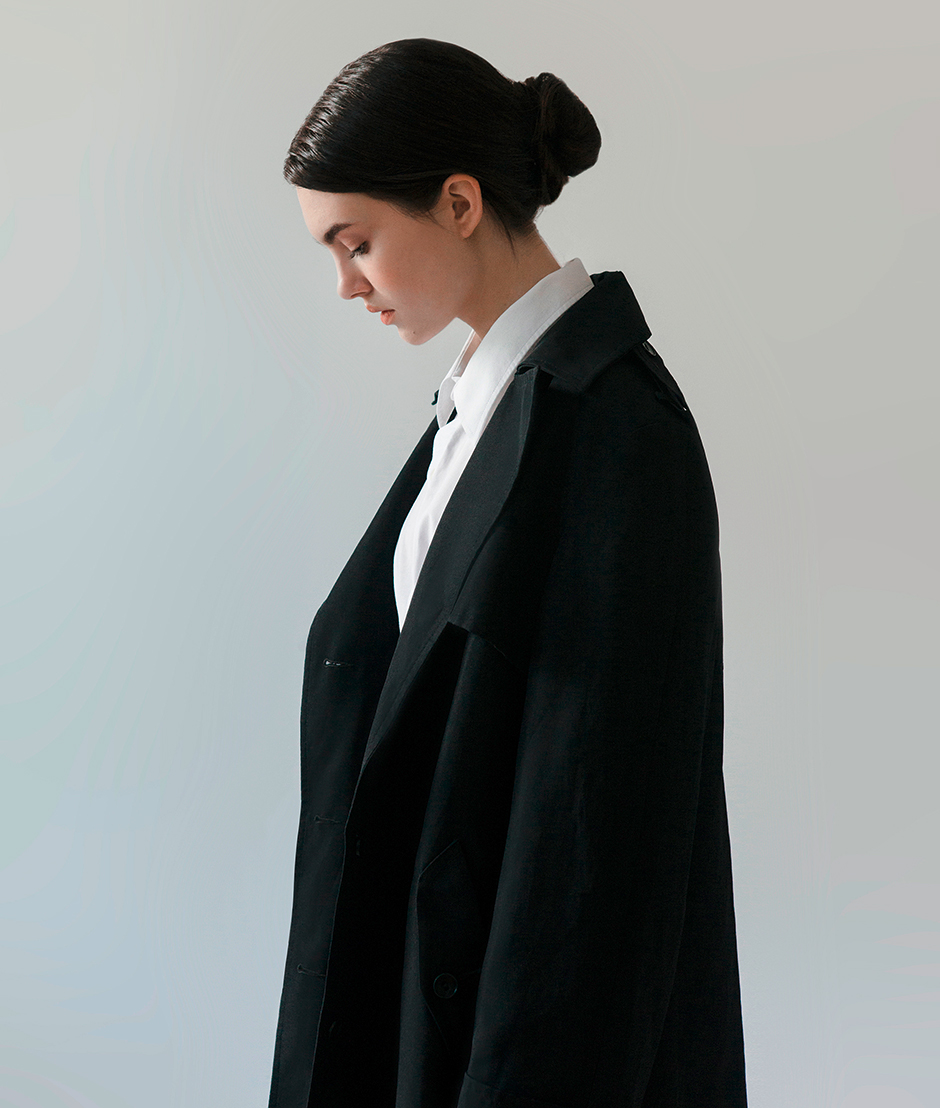 Junge Frau in weißer Bluse und schwarzem Mantel | Credit: iStock.com/ta-nya