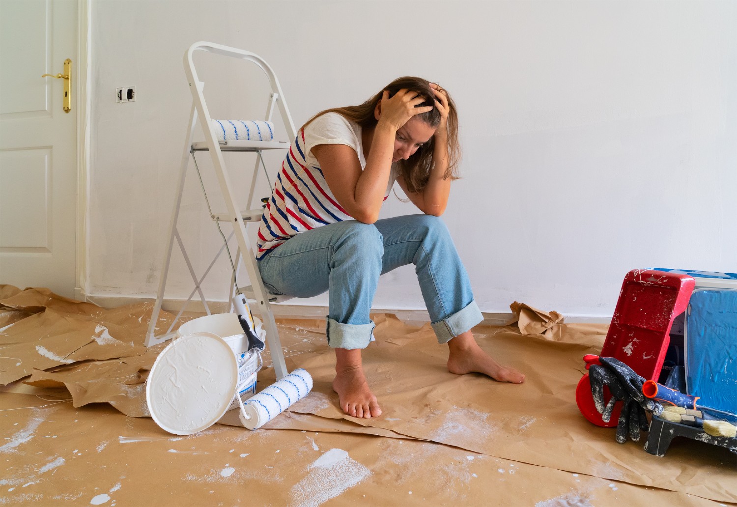 Frau sitzt frustriert unter Farbeimern | Credit: iStock.com/neirfy