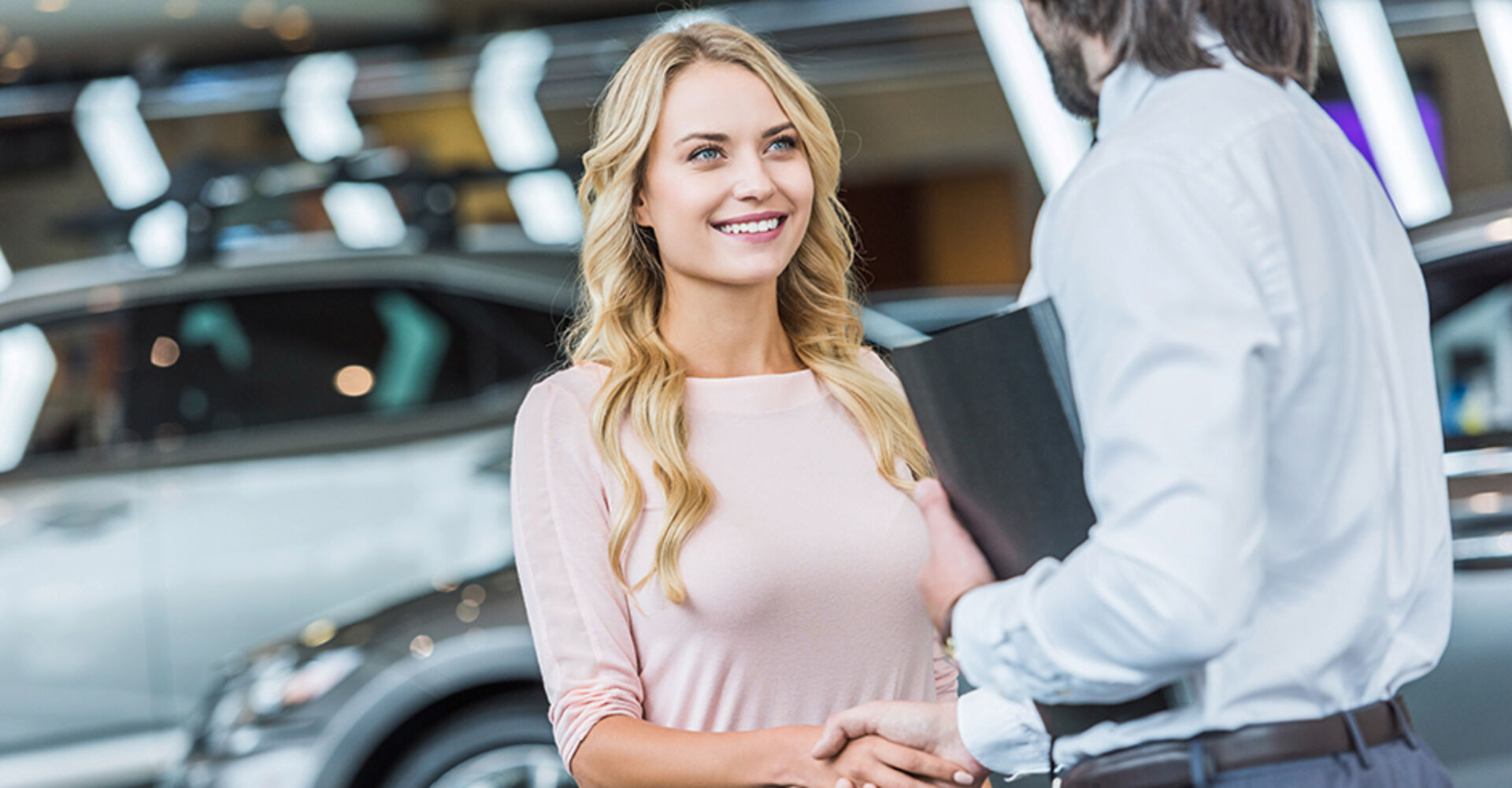 Junge Frau reicht Autohändler die Hand | Credit: Colurbox.de/#246329