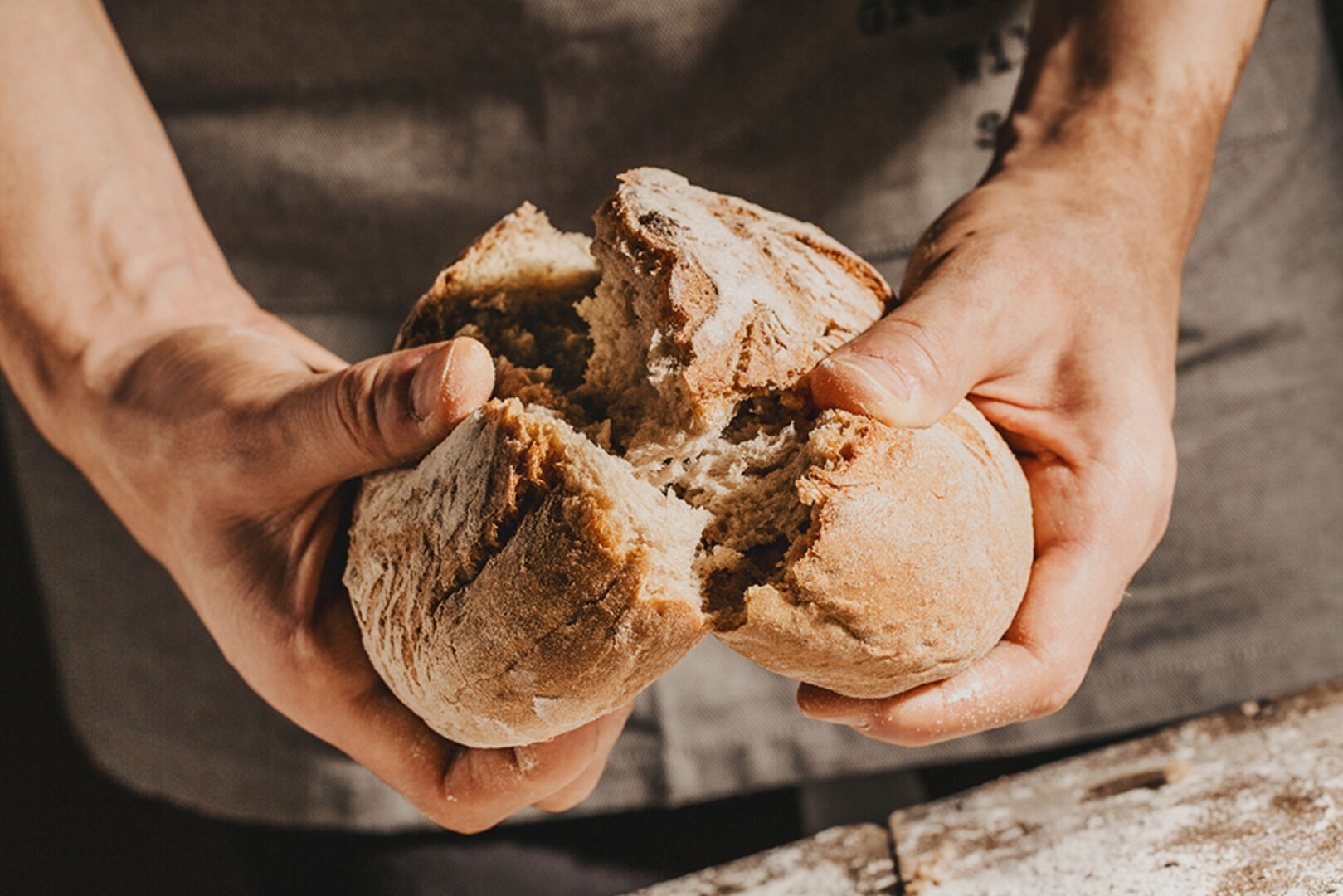 Mann bricht frisch gebackenes Brot | Credit: iStock.com/nerudol