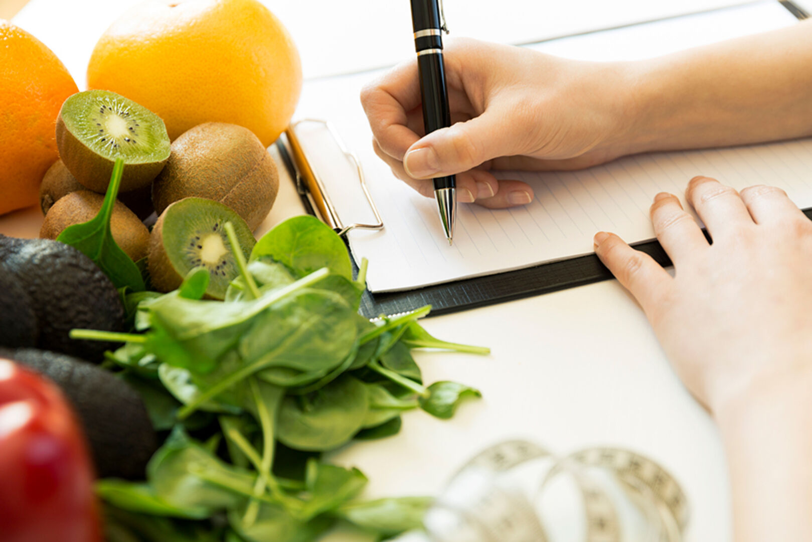 Frau führt ein Tagebuch über ihre Ernährungsgewohnheiten | Credit: iStock.com/artursfoto