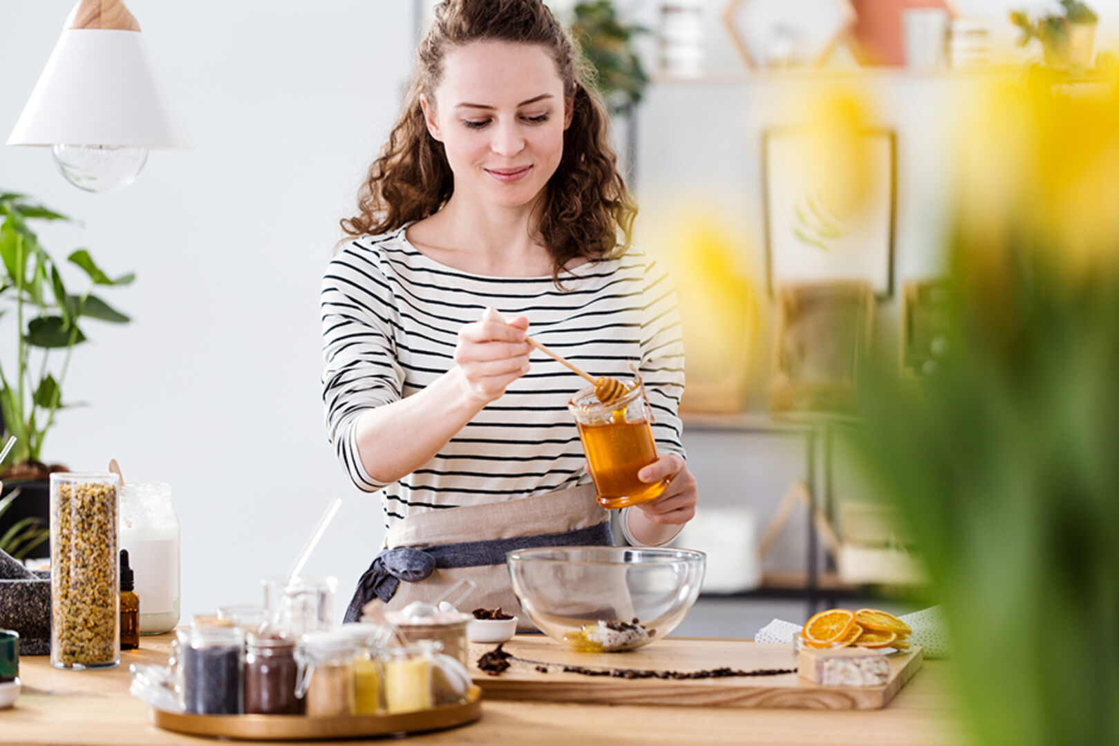 Junge Frau süßt ihr Gericht mit Honig | Credit: iStock.com/KatarzynaBialasiewicz