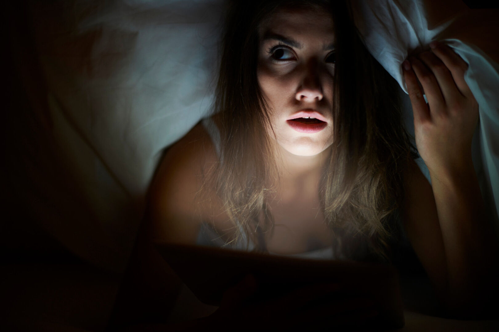 Frau sitzt mit Decke über dem Kopf | Credit: iStock.com/gpointstudio