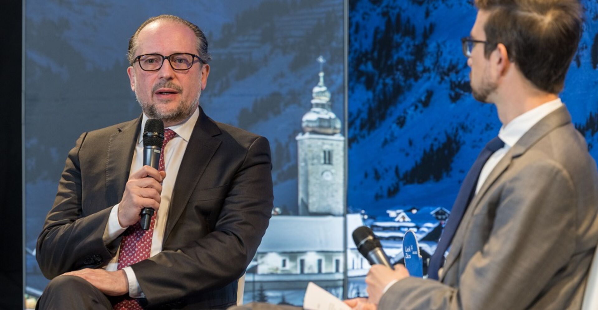 Außenminister Alexander Schallenberg mit Mikrofon. Er ist im Gespräch im Gespräch mit Ivo Mijnssen (NZZ, re.)