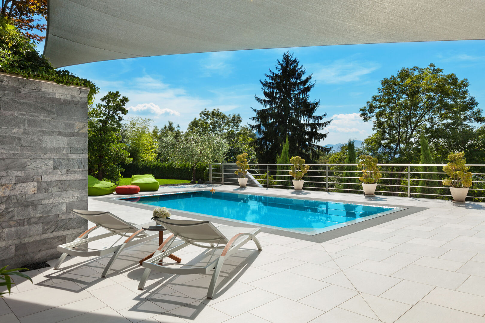 Eine luxuriöse Terrasse mit Swimmingpool und Blick auf einen Wald