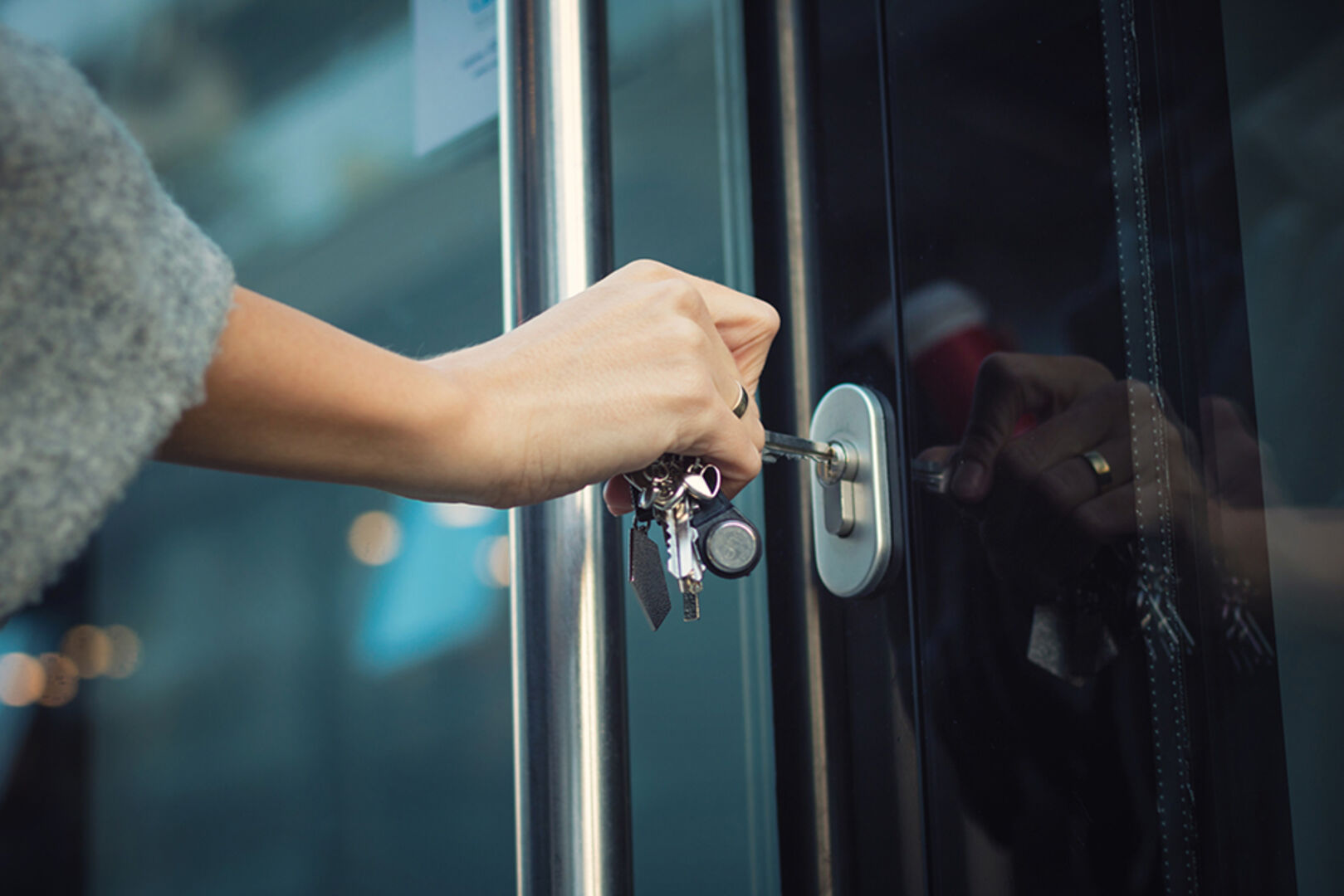 Junge Frau öffnet die Haustür mit ihrem Schlüssel | Credit: iStock.com/LumineImages