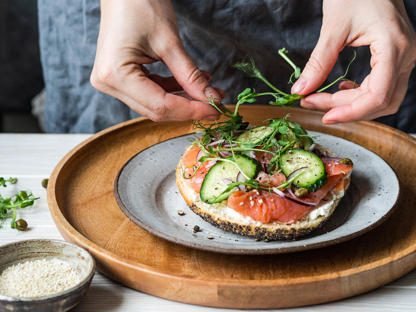 Frau richtet sich ein Lachsbrötchen | Credit: iStock.com/Olga Peshkova