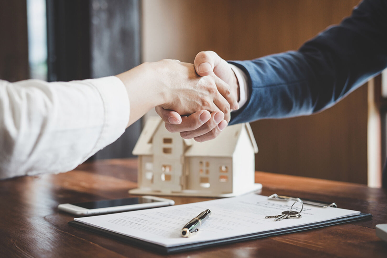 Kaufvertrag einer Immobilie wird per Handschlag besiegelt | Credit: iStock.com/Pattanaphong Khuankaew
