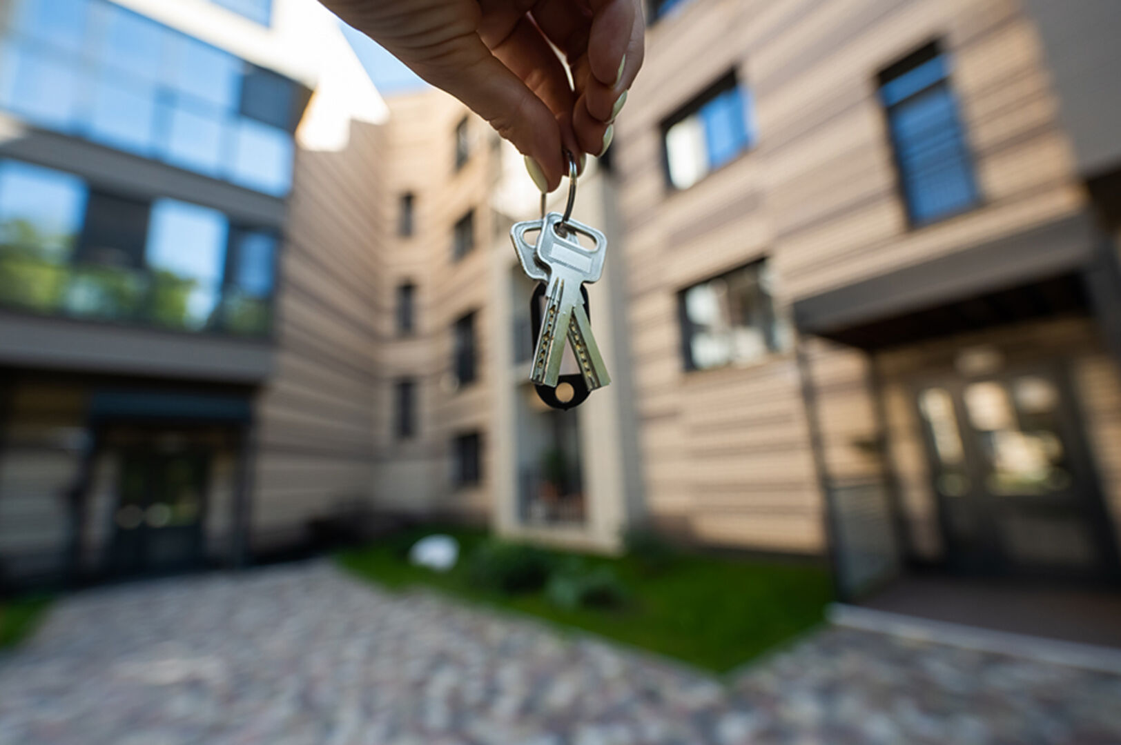 Frau hält Haustürschlüssel in die Luft | Credit: iStock.com/inside-studio